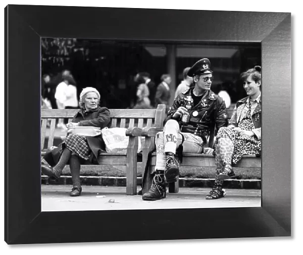 Two punk rockers sitting on a bench in Birmingham, seated next to them is an elderly lady