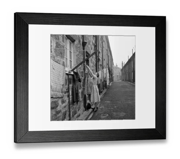 Framed Print : A woman hanging out her washing in a street in St Ives, Cornwall. 15th February 1954 Framed Print : A woman hanging out her washing in a street in St Ives, Cornwall. 15th February 1954