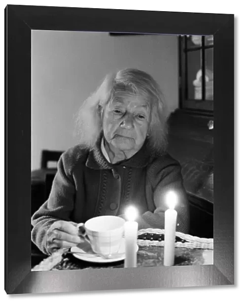 Elderly woman, drinking a cup of tea, by candlelight, Perry Barr, Birmingham