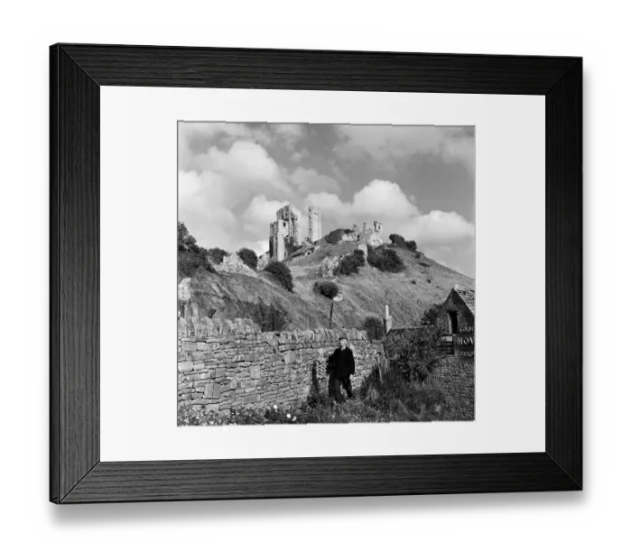 Framed Print : Corfe Castle, The Square, Wareham, Dorset, rises behind a drystone wall