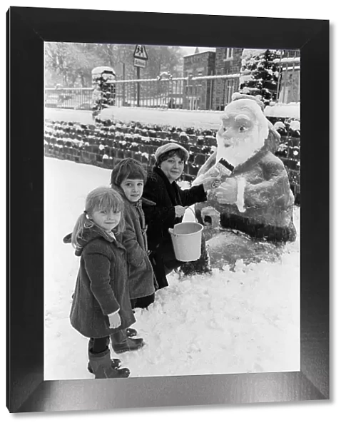 Skelmanthorpe First School pupils admire a snow sculpture of Father Christmas by Karen