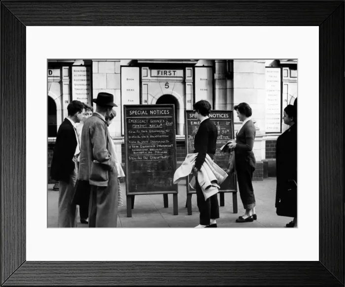 Framed Print : Holiday makers study notices giving details of the emergency rail services to Snow Hill