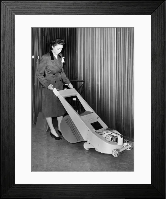 Framed Print : A woman trying out a stream lined lawn mower which can be driven by petrol or electric Framed Print : A woman trying out a stream lined lawn mower which can be driven by petrol or electric