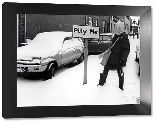 A young boy braves the snow on his paper round in the village of Pity Me in Durham