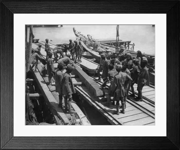Framed Print : Indian troops under the direction of British officers unload a barge on the Tigris River