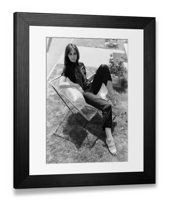 Framed Print : A display of modern furniture, a woman sitting on a transparent chair. 30th June 1969
