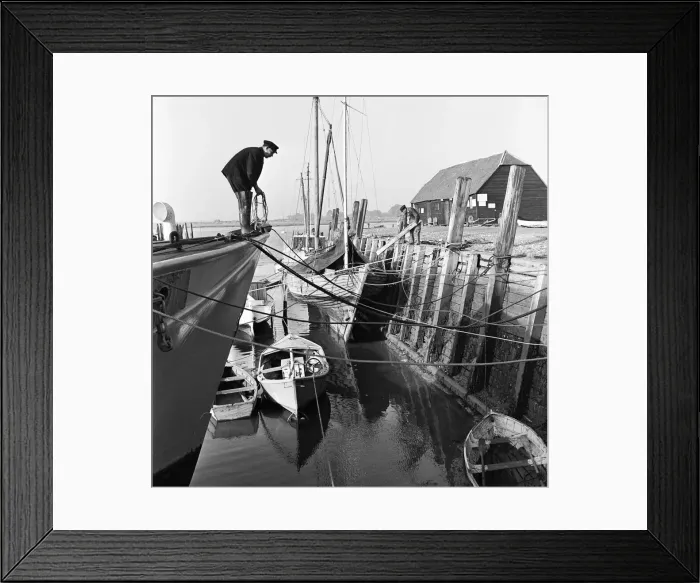 Framed Print : A fisherman mooring his boat at Bosham on the West Sussex Seafront. January 1953