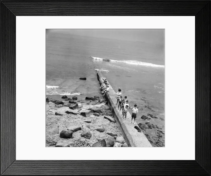 Framed Print : Holidaymakers on a sewerage pipe on the beach at Tynemouth near Newcastle Upon Tyne Framed Print : Holidaymakers on a sewerage pipe on the beach at Tynemouth near Newcastle Upon Tyne