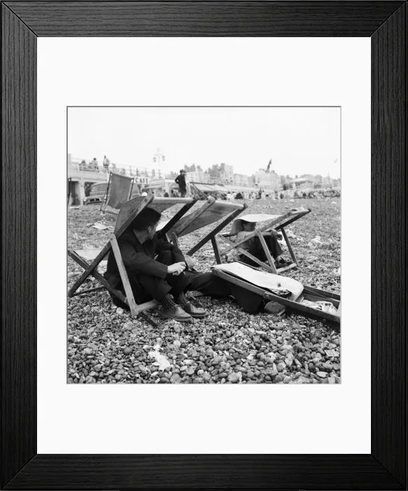 Framed Print : Beach scene Brighton, East Sussex. Holidaymaker seek shelter from a summer shower Framed Print : Beach scene Brighton, East Sussex. Holidaymaker seek shelter from a summer shower