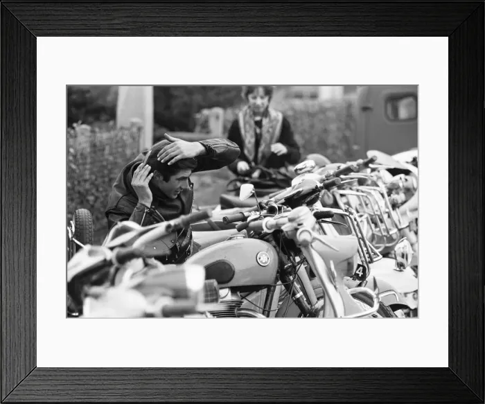 Framed Print : Rocker combs his hair using the mirror of a mods scooter on Clacton sea front Framed Print : Rocker combs his hair using the mirror of a mods scooter on Clacton sea front