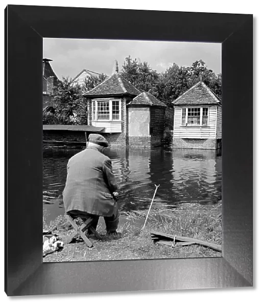 An elderly fisherman on the banks of the river Lea at Ware in Hertfordshire circa 1963