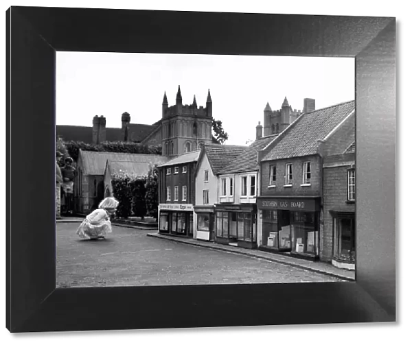 A child looking at the shops at Wimborne Minster Model Town & Gardens. Dorset. Circa 1955