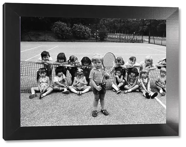 Three year old Daniel Jarmin holds a tennis racket as he poses with other friends in his