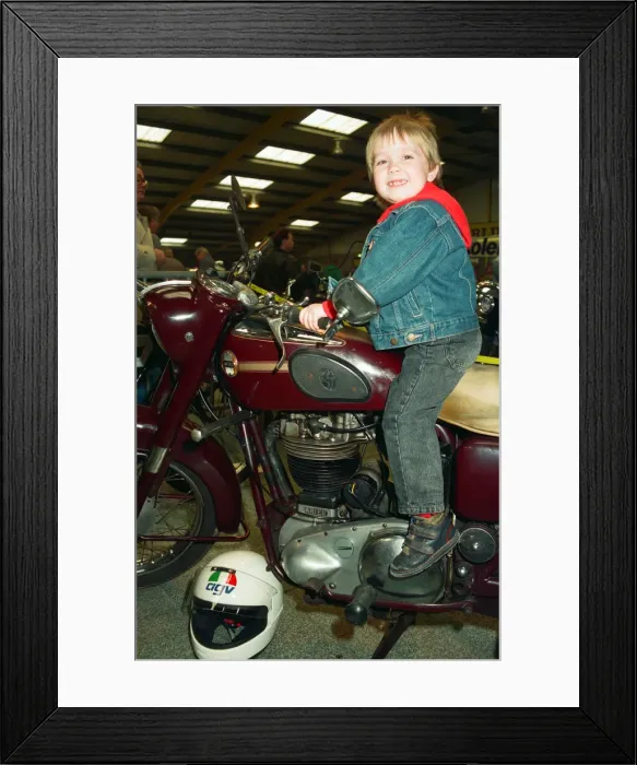 Framed Print : Michael Tilley, aged three and a half, tries out a 1956 Ariel 500cc at the Classic Bike