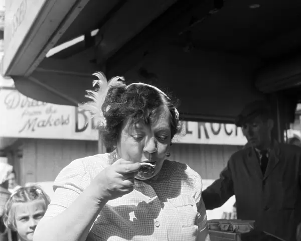 A woman eating oysters whilst on holiday in Blackpool, Lancashire. 3rd August 1953