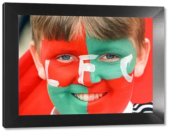 Young Liverpool fan with his face painted in team colours