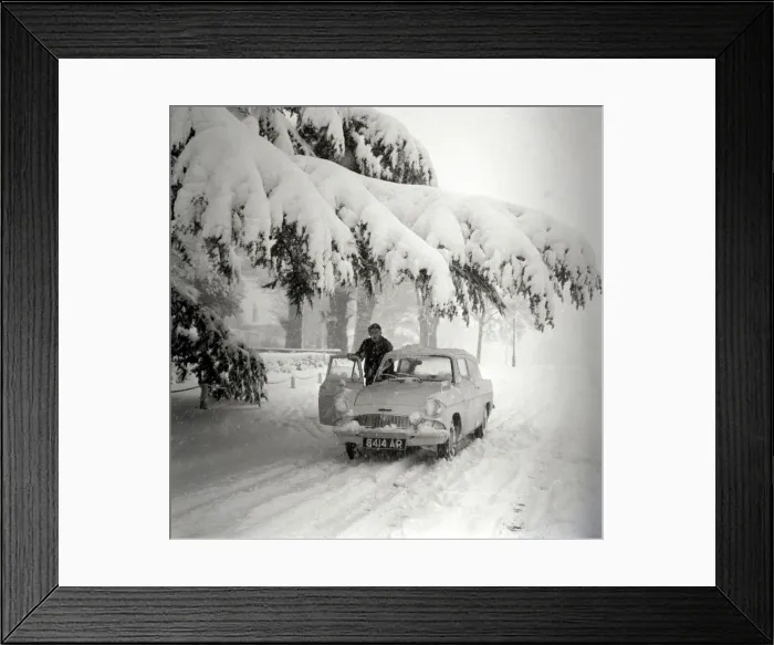 Framed Print : A motorist clears the snow off his car after a heavy fall in Hadley Wood Framed Print : A motorist clears the snow off his car after a heavy fall in Hadley Wood