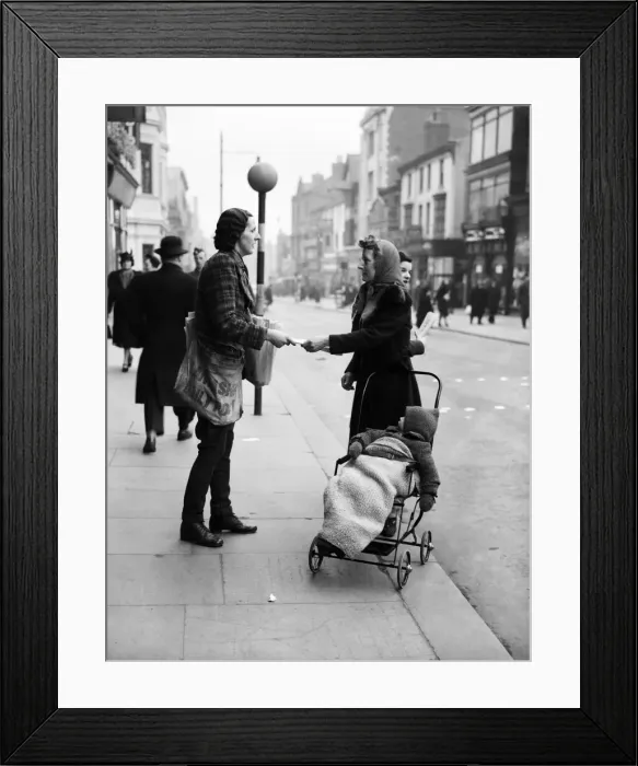 Framed Print : A female newspaper seller in Liverpool, selling a copy of the Daily Post to a mother in Framed Print : A female newspaper seller in Liverpool, selling a copy of the Daily Post to a mother in