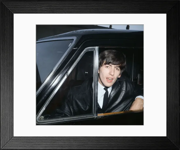 Framed Print : Beatles guitarist George Harrison leans out a car window during the band Framed Print : Beatles guitarist George Harrison leans out a car window during the band