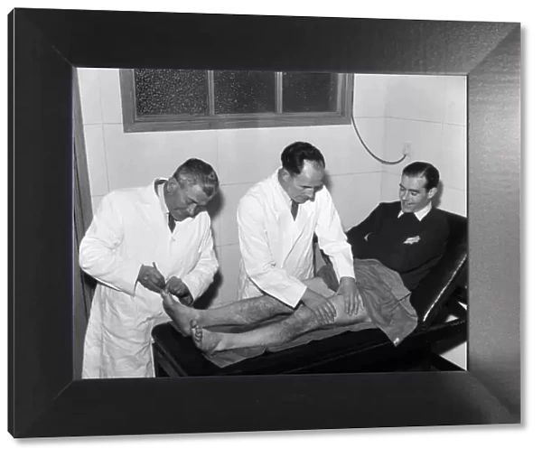 Wilf Dixon (centre), Southend United Trainer massages player Sam McCrory on the treatment