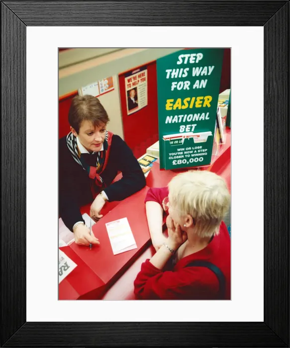 Framed Print : Chris Hudson, mangers of Ladbrokes in the Bigg Market, gives out last minute tips to Framed Print : Chris Hudson, mangers of Ladbrokes in the Bigg Market, gives out last minute tips to