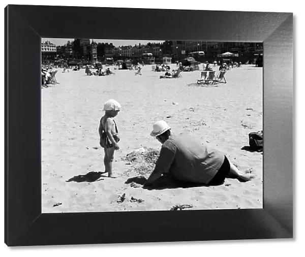Hot weather scenes in Margate, Kent. An adult and child playing on the beach