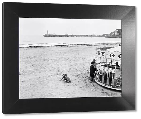 Scenes in Margate, Kent, during Good Friday. Two toddlers playing on the beach besides a