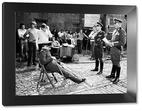 Actor David McCallum (seated) on the film set during filming of Colditz