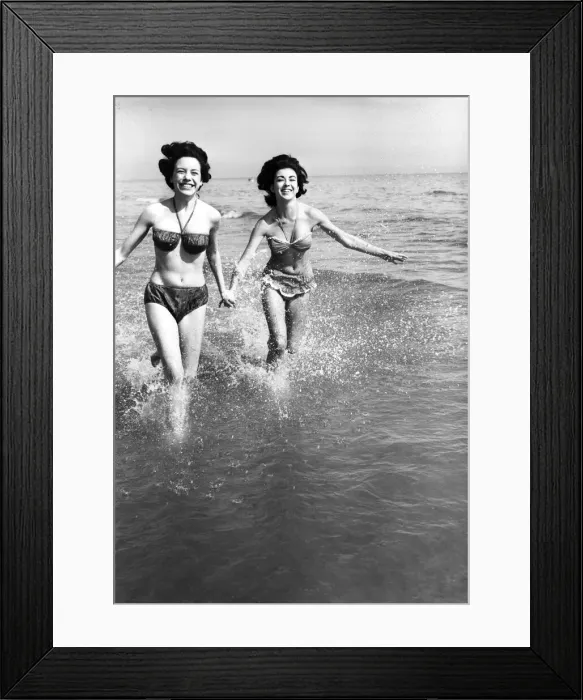 Framed Print : Hot weather scenes in Margate, Kent. Two young women running in the sea. 30th June 1961 Framed Print : Hot weather scenes in Margate, Kent. Two young women running in the sea. 30th June 1961