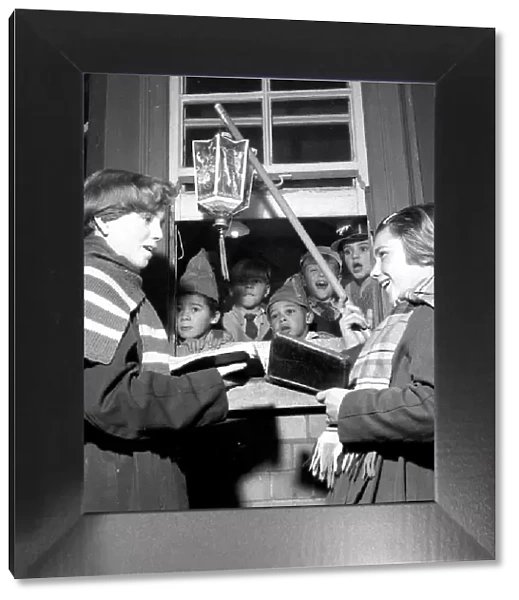 Children singing Christmas carols with a hanging lantern