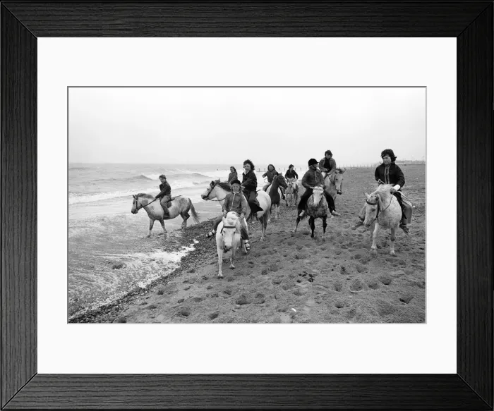 Framed Print : Children enjoying a seaside canter on the ponies despite the weather at Hornsea Framed Print : Children enjoying a seaside canter on the ponies despite the weather at Hornsea