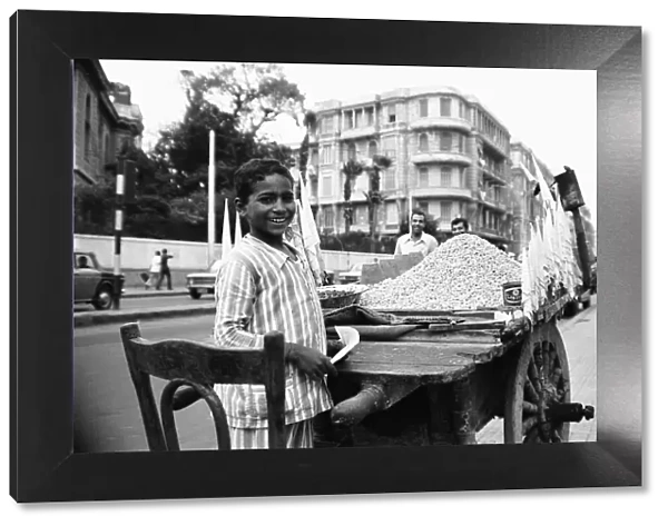 A child street vendor selling chick peas on the streets of Alexandria. 29th May 1976