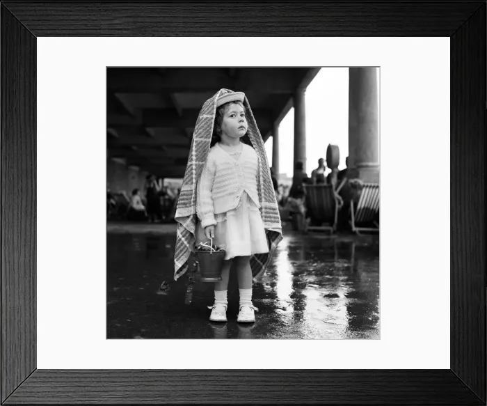 Framed Print : A small girl sheltering from the rain at Barry Island, Vale of Glamorgan, Wales Framed Print : A small girl sheltering from the rain at Barry Island, Vale of Glamorgan, Wales