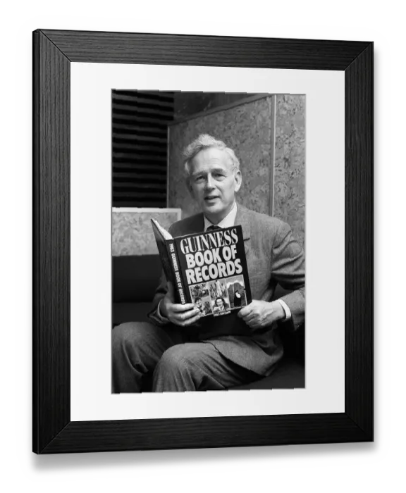 Framed Print : Norris McWhirter holding a copy of the Guinness Book of records Framed Print : Norris McWhirter holding a copy of the Guinness Book of records