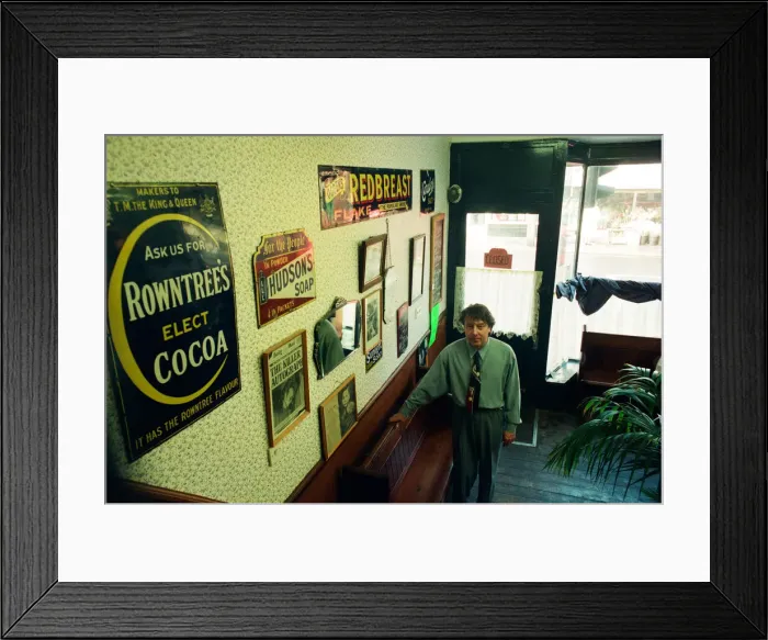 Framed Print : Redcar barber Mike Forbes with some of his collection of memorabilia in his shop Framed Print : Redcar barber Mike Forbes with some of his collection of memorabilia in his shop
