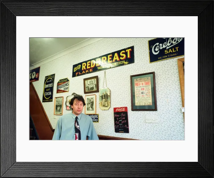 Framed Print : Redcar barber Mike Forbes with some of his collection of memorabilia in his shop Framed Print : Redcar barber Mike Forbes with some of his collection of memorabilia in his shop