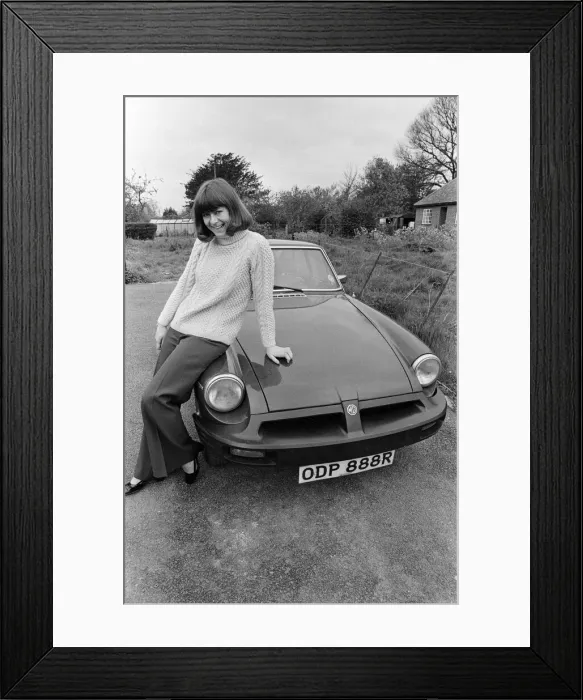 Framed Print : Pam Ayres poses beside her MGB sports car. 12th May 1977