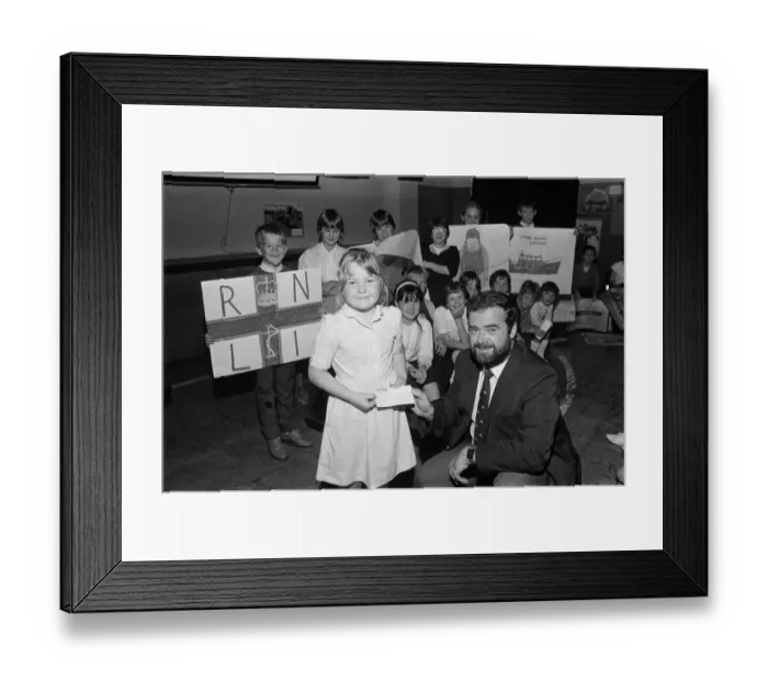 Framed Print : Seven-year old Adele Brooke presents a £588 cheque from Dalton Junior School to Mr