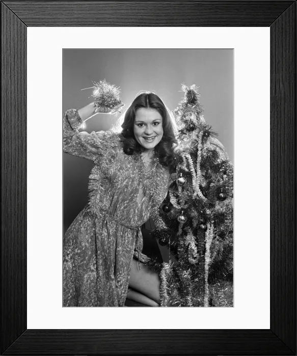 Framed Print : Model Leigh Lesley poses with a Christmas tree. 22nd December 1980 Framed Print : Model Leigh Lesley poses with a Christmas tree. 22nd December 1980