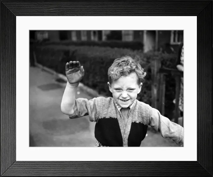 Framed Print : A boy plays on his tricycle on a council estate as his mother looks on 1955 Framed Print : A boy plays on his tricycle on a council estate as his mother looks on 1955