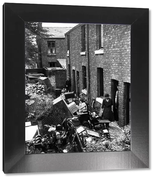 Bomb damage in Liverpool. Residents in these cottages salvaging their belongings after an