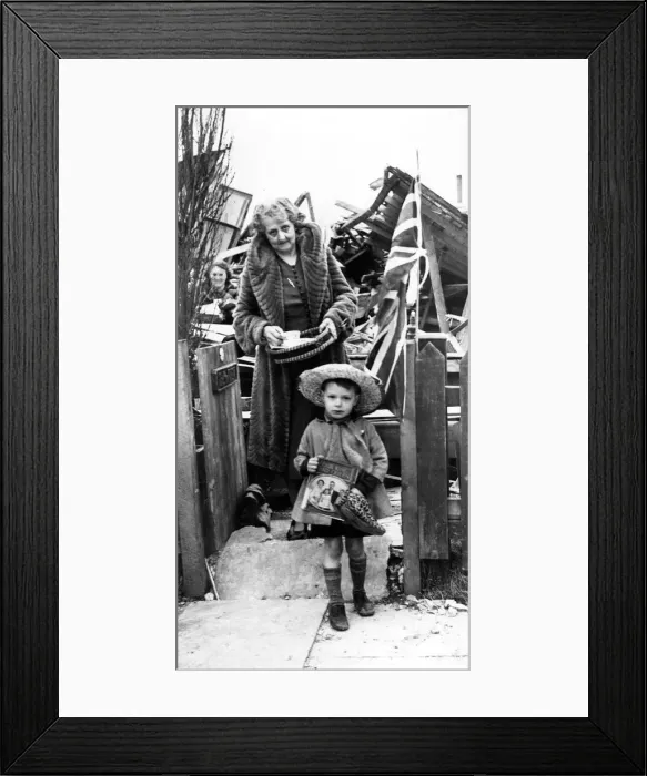 Framed Print : During the second world war, a little boy stands outside the shambles of his bombed home