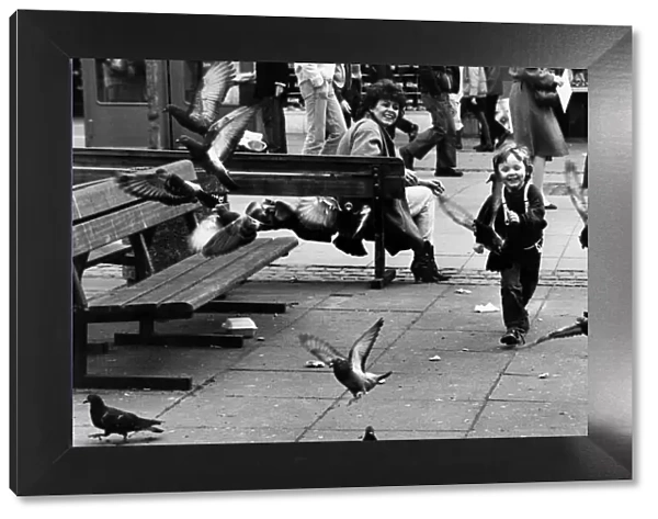 A young boy having fun chasing pigeons, Liverpool. 13th April 1984