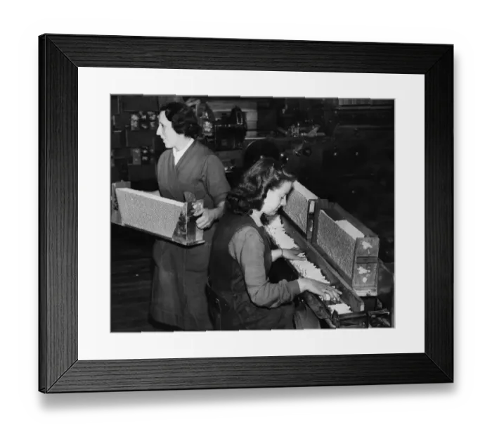 Framed Print : Women working on a cigarette production line. Cigarettes being manufactured at the rate