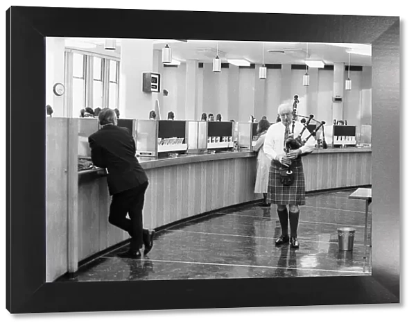 A bagpiper pipes the last day of business of 1970 in the Lloyds banking hall at