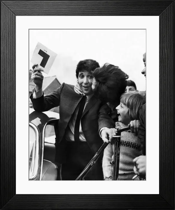 Framed Print : Tom Jones gets a kiss from a fan as he passes his Driving Learners test at Newport