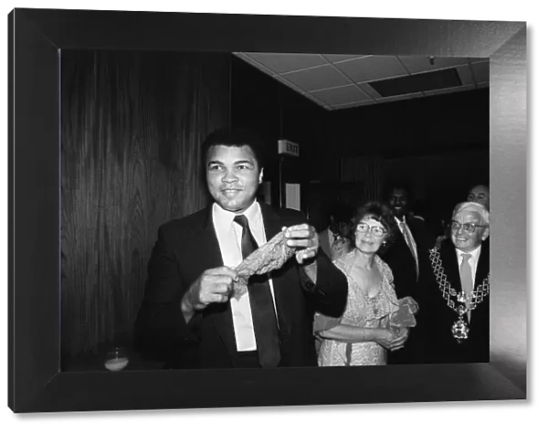 Muhammad Ali (left) shows off a conjuring trick when visiting Birmingham