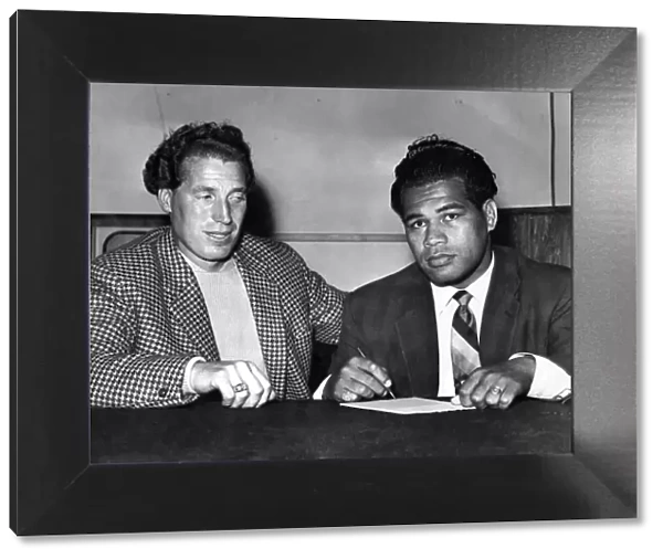 Kitione Lave (Right) and just Burton Sign the contract for their fight. September 1958