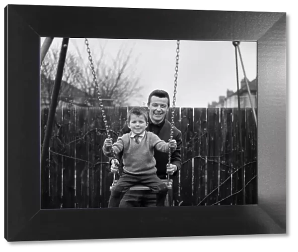 West Ham footballer Johnny Byrne celebrates his England call up with a swing with his son
