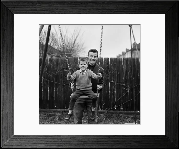 Framed Print : West Ham footballer Johnny Byrne celebrates his England call up with a swing with his son Framed Print : West Ham footballer Johnny Byrne celebrates his England call up with a swing with his son